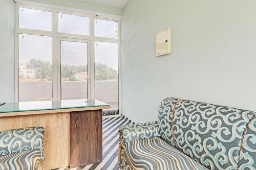a living room with a couch and a window at Collection O Maharaja Resort in Varanasi