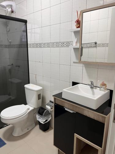 a bathroom with a toilet and a sink and a mirror at Apartamento Centro Ametista do Sul in Ametista do Sul