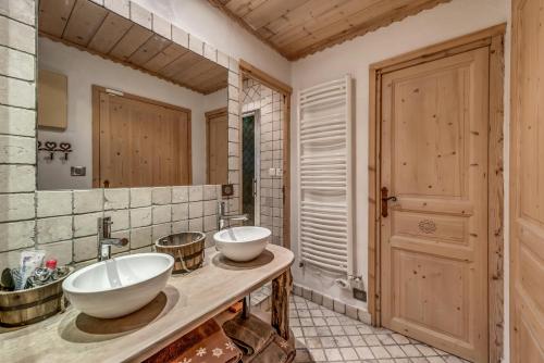 une salle de bain avec deux lavabos et un grand miroir dans l'établissement Résidence Le Grand Bouquetin - 6 Pièces pour 12 Personnes MAE-5554, à Champagny-en-Vanoise