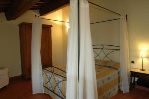 um quarto com uma cama de dossel em metal em Appartement in Figline Valdarno mit Terrasse, Grill und Garten em Figline Valdarno