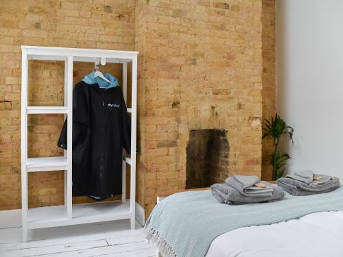 une chambre avec un lit et une chemise sur une étagère dans l'établissement Beach View House, à Margate