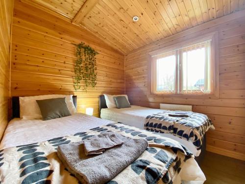 a room with two beds in a log cabin at Magnolia Lodge-uk46280 in Camerton