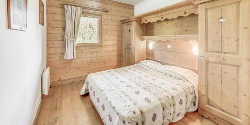 une chambre avec un lit dans une pièce en bois dans l'établissement Résidence Les Alpages - 3 Pièces pour 6 Personnes MAE-3934, à Champagny-en-Vanoise