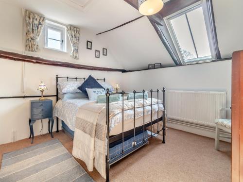 a bedroom with a bed in a room with windows at Rose Cottage - Ukc4238 in Great Snoring