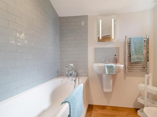 a bathroom with a tub and a sink at Rose Cottage - Ukc4238 in Great Snoring