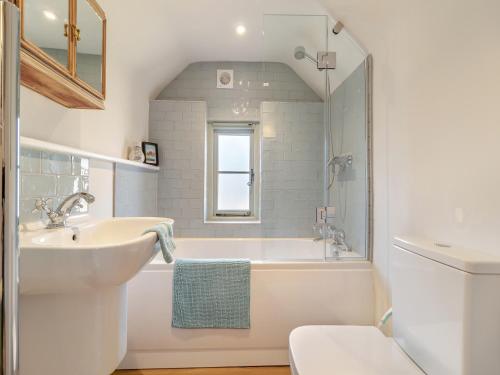 a bathroom with a tub and a sink and a toilet at Vine Cottage - Ukc4237 in Great Snoring