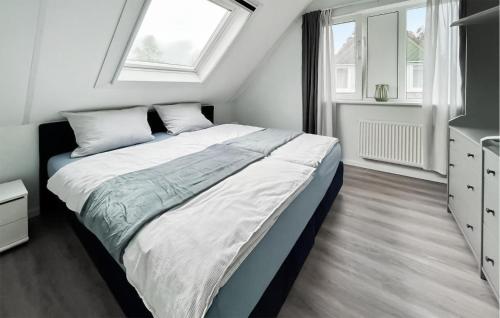 een slaapkamer met een bed met witte lakens en een raam bij Amazing Home In Vlagtwedde With Indoor Swimming Pool in Vlagtwedde