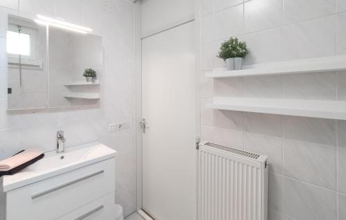 een witte badkamer met een wastafel en een spiegel bij Amazing Home In Vlagtwedde With Indoor Swimming Pool in Vlagtwedde