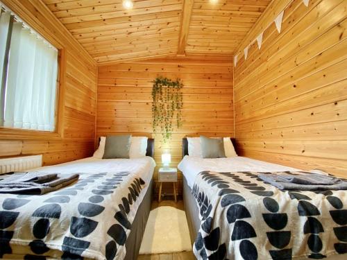 Zimmer mit 2 Betten in einer Holzhütte in der Unterkunft Pine Lodge - Uk46279 in Camerton