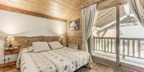 une chambre avec un lit et une grande fenêtre dans l'établissement Résidence Les Alpages - 4 Pièces pour 8 Personnes MAE-3044, à Champagny-en-Vanoise