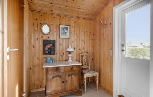 Habitación con pared de madera, mesa y espejo. en Gorgeous Home In Bogense With Kitchen, en Bogense