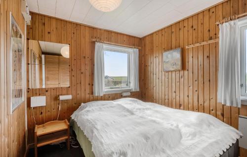 a bedroom with wooden walls and a bed with a window at Gorgeous Home In Bogense With Kitchen in Bogense