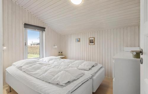 a large white bed in a room with a window at 3 Bedroom Amazing Home In Bogense in Bogense