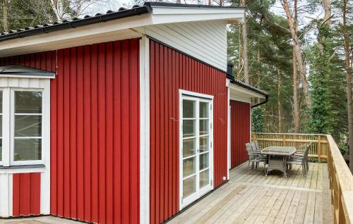 a red and white shed with a table on a deck at Amazing Home In Sjöbo With Wifi in Sjöbo