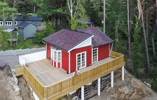 a small red house on top of a deck at Amazing Home In Sjöbo With Wifi in Sjöbo
