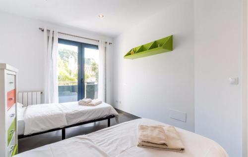 Dieses weiße Zimmer verfügt über 2 Betten und ein Fenster. in der Unterkunft Gorgeous Home In Alcudia With Outdoor Swimming Pool in Alcúdia