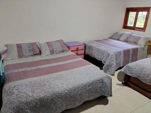 a bedroom with two beds and a window at Chalet La Estancia - Parque del Café in Montenegro