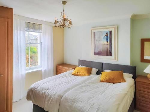 een slaapkamer met een groot bed met 2 oranje kussens bij Little Hills in Keswick