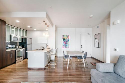 Brand New 2BR Luxury Apartment WeHo في لوس أنجلوس: مطبخ وغرفة معيشة مع طاولة وأريكة