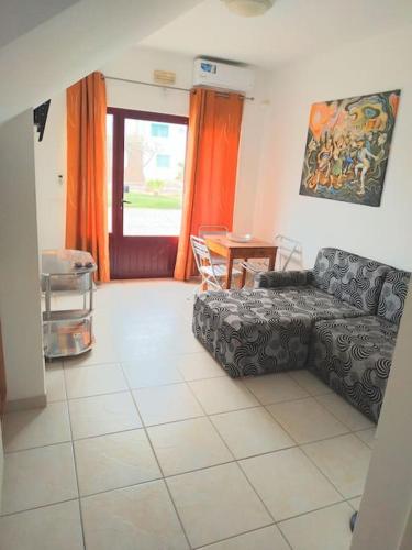a living room with a couch and a table at Murdeira H in Palha Verde