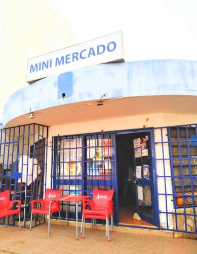 a store with red chairs and a table in front at Murdeira H in Palha Verde