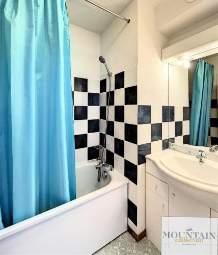La salle de bains est pourvue d'un rideau de douche bleu et d'un lavabo. dans l'établissement Résidence Pistes - Appartement spacieux · Proche des pistes · Balcon vue pistes MAE-3464, à Villarembert