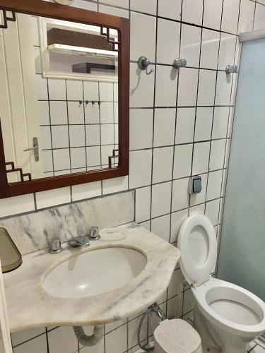 a bathroom with a sink and a toilet and a mirror at CASA EM GUARAPARI in Guarapari