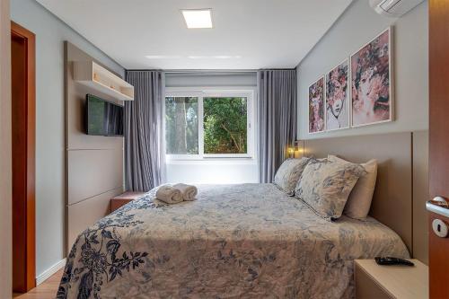 ein Schlafzimmer mit einem Bett mit zwei Handtüchern darauf in der Unterkunft Casa em condomínio até 8 p e 2 vagas in Canela