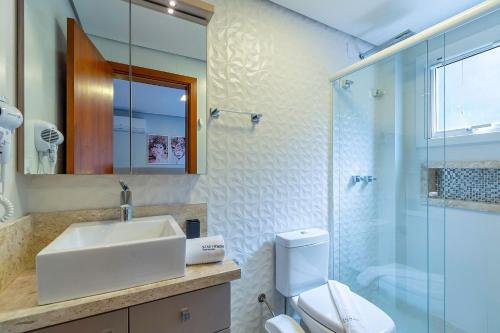 ein Badezimmer mit Waschbecken, Toilette und Dusche in der Unterkunft Casa em condomínio até 8 p e 2 vagas in Canela