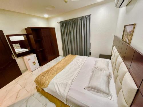 Un dormitorio con una cama grande y una ventana. en مرفق ضيافة خاص - شقة عائلية, en Al Fayşalīyah