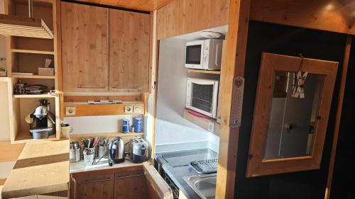 une petite cuisine avec un évier et un micro-ondes dans l'établissement Résidence Archeboc - Appartement 4 personnes à Arc 1800 proche des pistes dans le village de Charmettoger MAE-2194, à Arc 1800