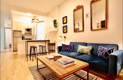 ein Wohnzimmer mit einem blauen Sofa und einem Tisch in der Unterkunft Medina’s estate in Bronx