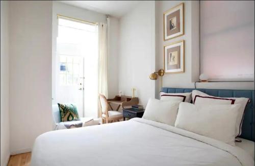 Un dormitorio con una gran cama blanca y una ventana en Medina’s estate en Bronx