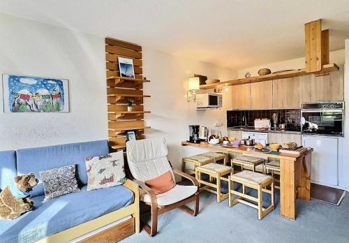 un salon avec un canapé et une cuisine dans l'établissement Résidence Le Villaret - 2 pièces spacieux pour 5 personnes situé au pied des pistes de 