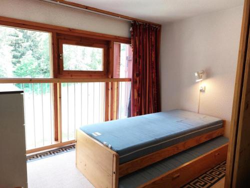 um quarto com uma cama em frente a uma janela em Résidence Aiguille Grive Bat Iii - 3 Pièces pour 6 Personnes 441 em Arc 1800