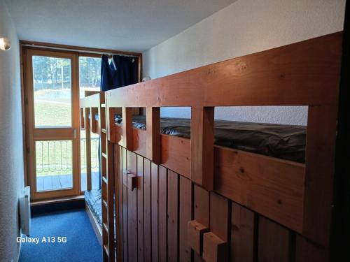 Cette chambre dispose de lits superposés en bois et d'une fenêtre. dans l'établissement Résidence Tournavelles - Appartement 2 pièces 7 personnes en duplex, au pied des pistes et des commerces, proche de l'ESF et de la garderie dans le villa MAE-5091, à Arc 1800
