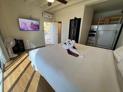 two white swans sitting on a bed in a room at AT SEA Patong in Patong Beach
