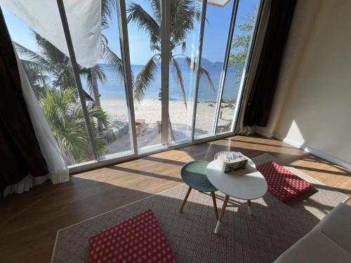 a living room with a table and a view of the beach at AT SEA Patong in Patong Beach