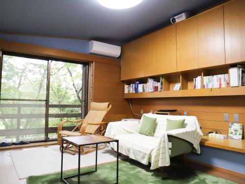 Habitación con cama, mesa y silla en ～みらい荘～　天然温泉付き一日一組様限定の６４坪広々民泊別荘, en Kirishima