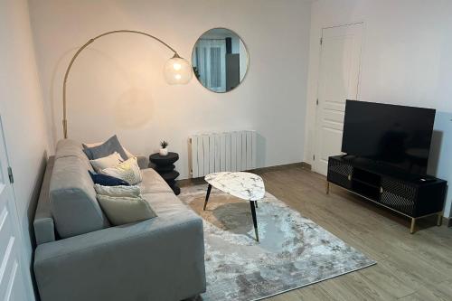 ein Wohnzimmer mit einem Sofa und einem Flachbild-TV in der Unterkunft Bondy15 Gare Paris Disney in Bondy