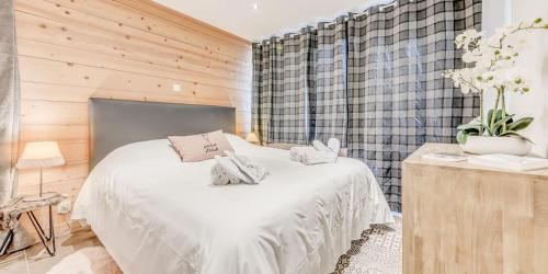 a bedroom with a white bed and a wooden wall at Résidence Hameaux De Toviere - 3 Pièces pour 7 Personnes 211 in Tignes