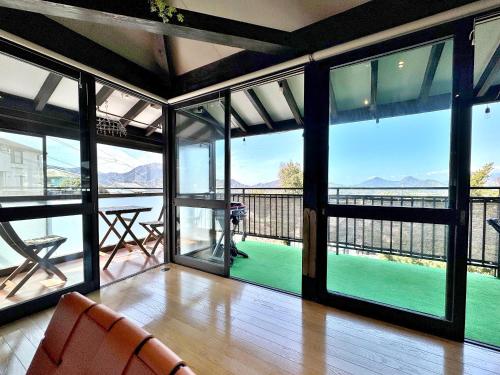 a living room with glass doors and a view of the ocean at Izu Ricca in Izunokuni