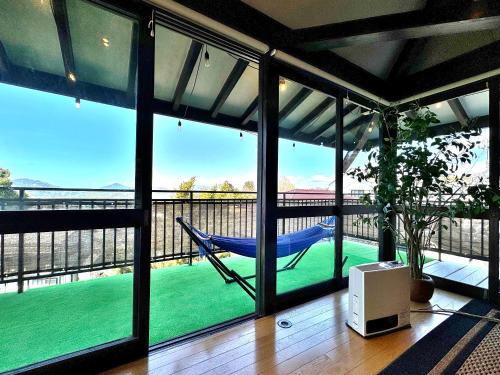 a porch with a hammock and a view of the water at Izu Ricca in Izunokuni