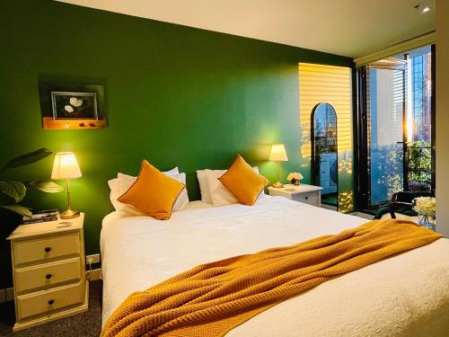 een slaapkamer met een groot bed met een groene muur bij Extraordinary holiday stay for Melbourne explore in Melbourne