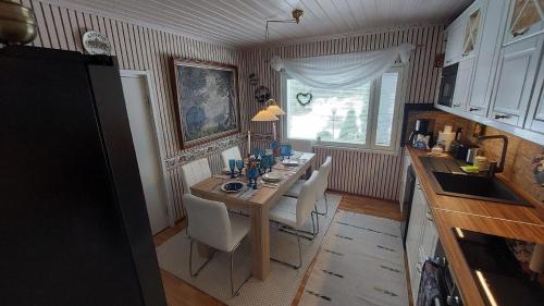 eine Küche mit einem Holztisch mit Stühlen und einem Esszimmer in der Unterkunft Ferienhaus für 5 Personen ca 120 qm in Leppävirta, Iso-Kalla-Seen in Leppävirta