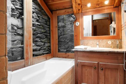 a bathroom with a bath tub and a sink at Chalet Les Champs Du Pont - Chalets pour 15 Personnes 611 in Tignes