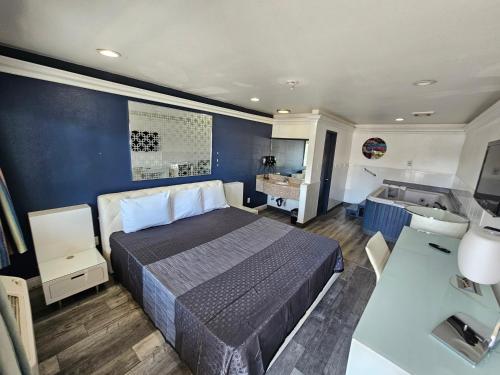 ein Schlafzimmer mit einem Bett und ein Badezimmer mit einem Waschbecken in der Unterkunft Flamingo Inn in Rosemead