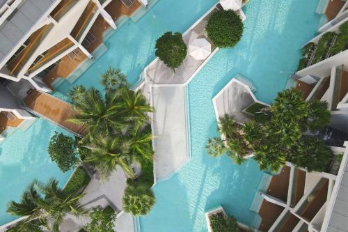 an overhead view of a swimming pool with palm trees at Wyndham Grand Nai Harn Beach Phuket in Nai Harn Beach