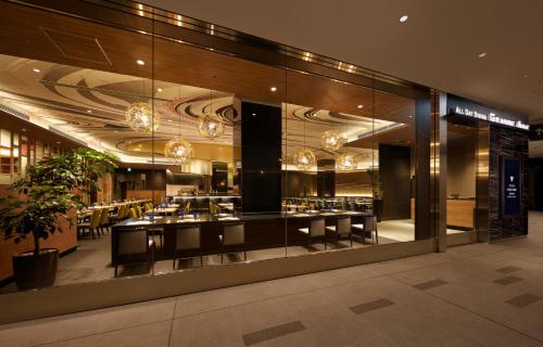 a restaurant in a building with a large glass window at Villa Fontaine Premier Haneda Airport in Tokyo