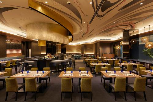 a restaurant with tables and chairs and a bar at Villa Fontaine Premier Haneda Airport in Tokyo